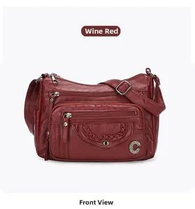 Detailed front view of wine red crossbody bag featuring multiple zippers and soft texture