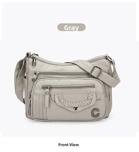 Front detail of grey crossbody bag with woven trim, C-logo and multiple zipper pockets