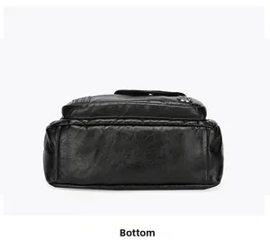 Detailed view of the flat bottom on a black litchi pattern faux leather crossbody bag