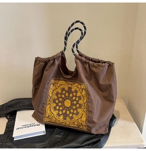 Brown nylon tote bag with yellow floral embroidery and drawstring closure detail