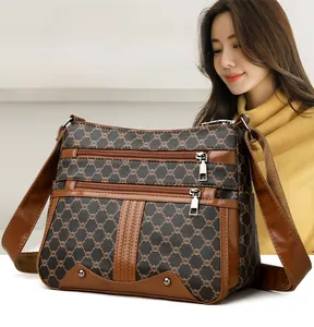 Detail of crossbody bag featuring geometric patterns and multi-layer zipper pockets