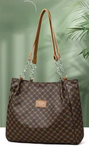 Close-up of vintage faux leather tote bag with metallic chain handles and logo detail