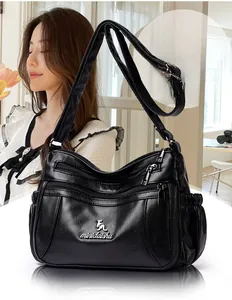Close-up of black lychee texture shoulder bag with multiple zipper compartments and metal logo