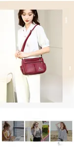 Detail view of red textured leather crossbody bag with multiple zippers and kangaroo logo