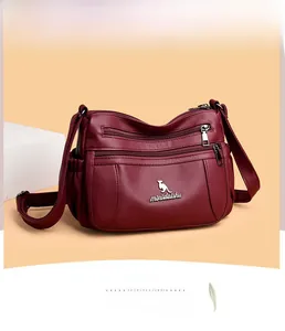 Detail view of burgundy leather shoulder bag with multi-zip pockets and kangaroo logo