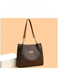 Detail of vintage brown monogram tote bag with leather strap and silver chain hardware