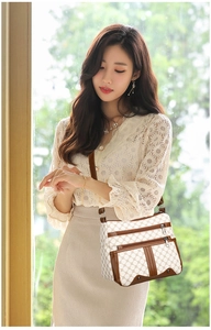 Detail of white printed tote bag with dual front zippers and reinforced leather corners