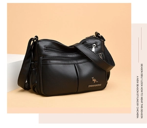 Detail of black pebbled leather handbag with double zipper pockets and kangaroo metal logo