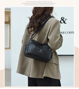 Detailed view of black leather crossbody bag with multiple zipper compartments and kangaroo logo