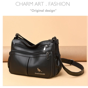 Detail of black pebbled leather crossbody bag featuring three front zipper compartments