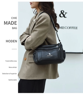 Detail view of the black multi-pocket shoulder bag with silver zippers and kangaroo logo