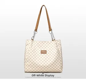 Detail of off-white PU leather tote with dark geometric patterns and metallic chain strap