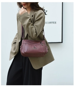 Deep burgundy multi-zipper crossbody bag with premium soft leather texture and metal logo