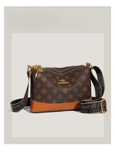 Detail of brown soft leather shoulder bag with kangaroo logo and printed canvas strap