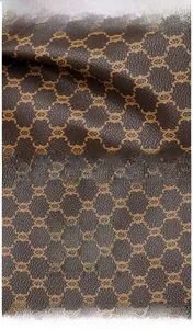 Detailed view of brown vintage monogram faux leather tote bag with embossed logo tag