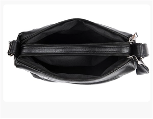 Internal view of black textured leather bag showing multiple functional compartments and zippers
