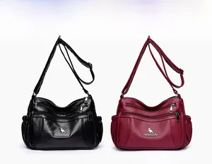 Detail view of multi-zipper crossbody bags in black and burgundy with pebble leather texture