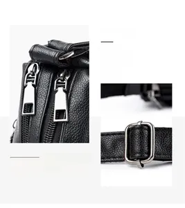 Detail of silver dual zippers and square adjustment buckle on black lychee leather bag