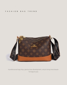 Detail view of the multi-zipper compartments and kangaroo logo on retro leather shoulder bag