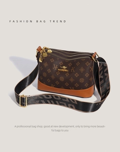 Detailed view of brown monogram crossbody bag with triple zippers and woven strap