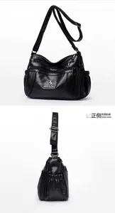 Detail of black pebbled leather crossbody bag showing multiple zip pockets and compartments