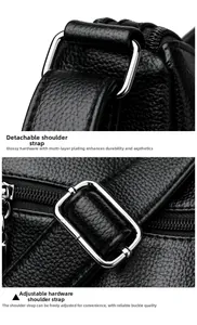 Close-up of silver metal hardware and adjustable strap buckle on black leather tote bag
