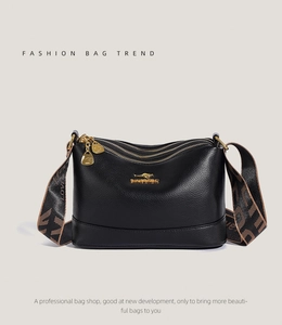 Detail of black lychee grain leather crossbody bag with three zippers and wide strap