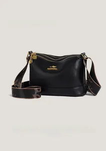 Detailed view of black litchi grain leather crossbody bag with triple zippers and wide strap