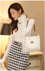 Detail of cream tote bag with brown geometric pattern and chain strap on a model