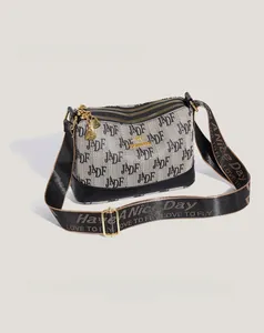 Detail of grey jacquard crossbody bag with double zippers and golden kangaroo logo