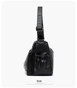 Side view of black pebble leather crossbody bag with elastic pocket and adjustable strap