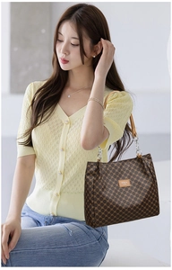 Brown vintage PU leather tote bag with chain strap styled with yellow knit cardigan