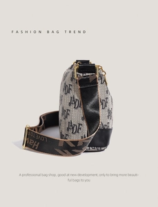Detail of jacquard fabric shoulder bag with leather trim and adjustable metal buckle