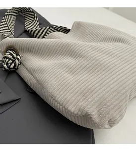 Detail of corduroy tote bag with woven geometric shoulder strap and metal ring