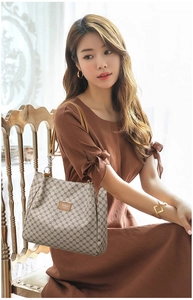 Detail of vintage geometric print tote bag with brown leather label and metal chain strap