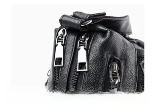 Detailed close-up of premium gunmetal dual zippers on black lychee grain leather bag