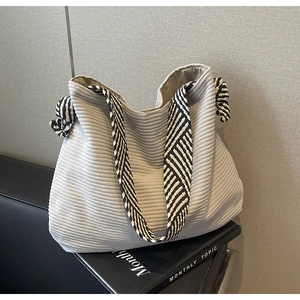 Detail of light grey corduroy tote bag with black and white geometric pattern wide strap