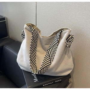 Detail view of grey corduroy tote bag with black and white patterned shoulder strap