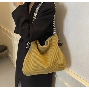 Detail of ginger yellow corduroy tote bag featuring black and white woven rope strap