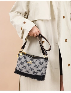 Detail of soft leather shoulder bag with triple zipper and embossed kangaroo logo