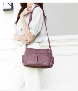 Detail view of purple multi-layer textured leather crossbody bag with metal hardware
