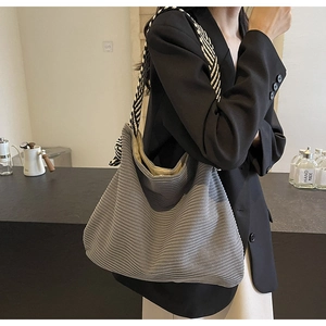 Detail of grey corduroy tote bag featuring black and white woven rope shoulder straps
