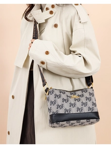 Detail of printed canvas crossbody bag with kangaroo gold logo and wide shoulder strap