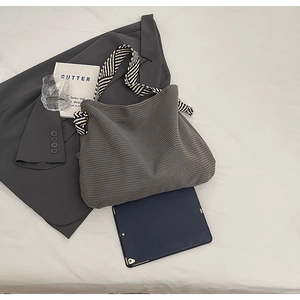Detail of grey corduroy tote bag with black and white striped strap and large capacity