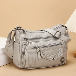 Light gray multi-pocket crossbody bag with adjustable strap and metallic charm detail