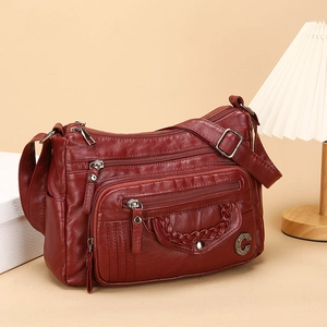 Burgundy faux leather crossbody bag with multiple zip pockets and metal logo detail