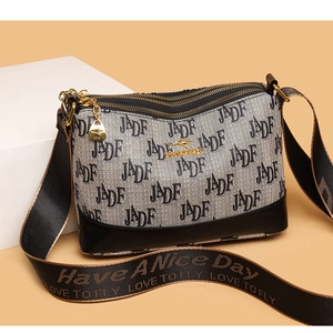 Detail of three-layer zipper crossbody bag with grey letter print and black wide strap