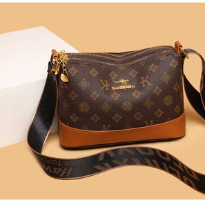 Detail of soft brown leather crossbody bag with kangaroo logo and wide woven shoulder strap
