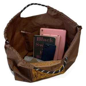 Brown canvas tote bag with ethnic embroidery and striped rope handles showing large capacity