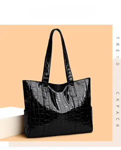 Detail of glossy black faux crocodile embossed leather on a large tote bag